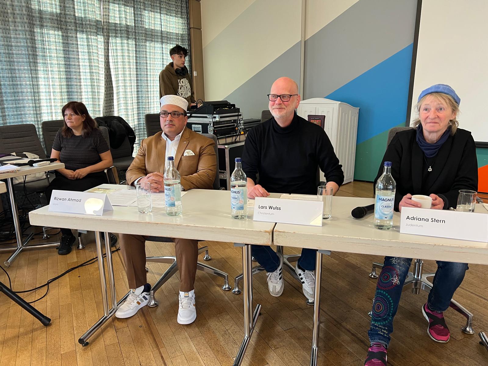 Vier Personen sitzen an einem Podiumstisch.