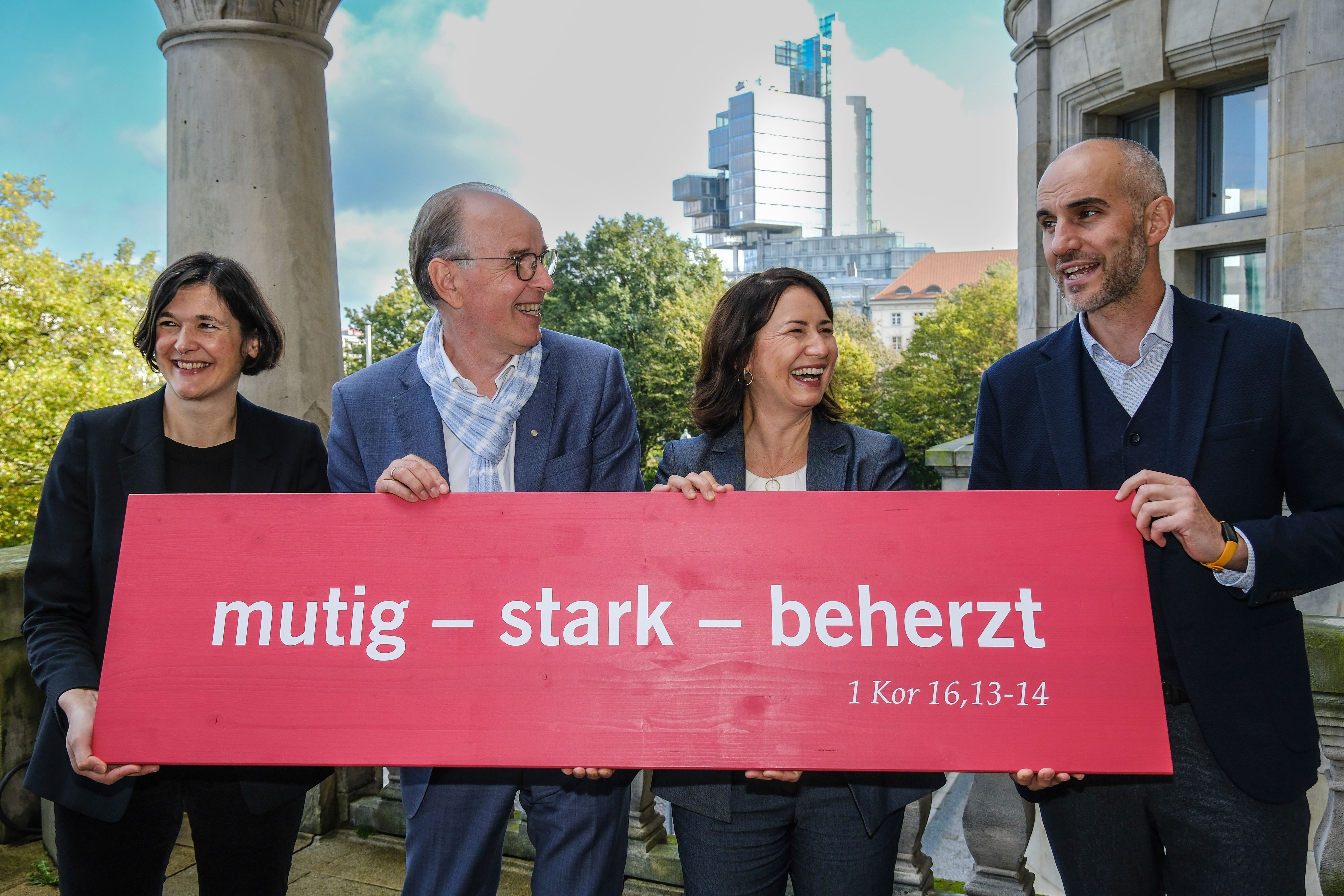 Vier Personen halten ein Banner mit der Aufschrift "mutig – stark – beherzt".