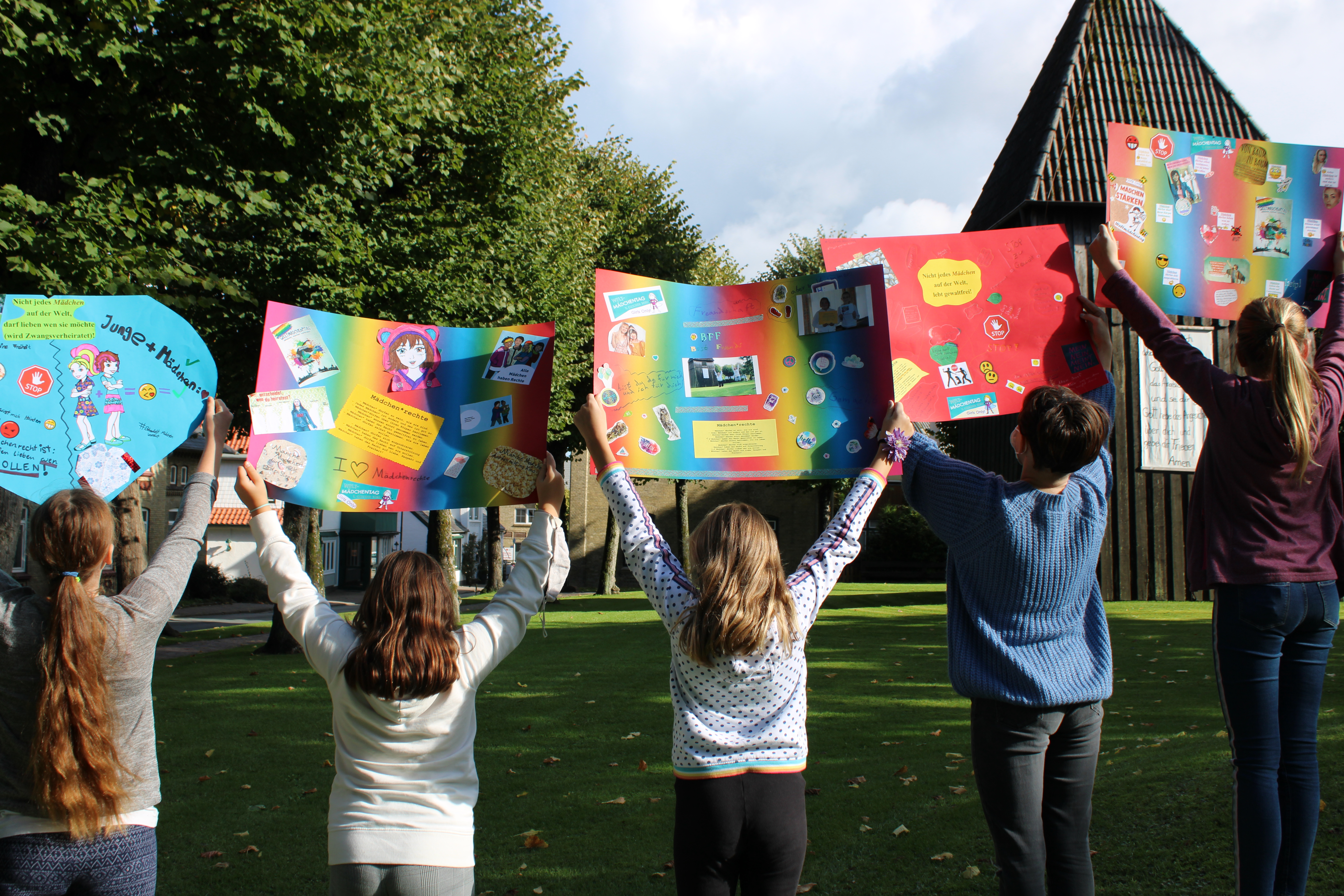 Vier Personen halten ein Banner mit der Aufschrift "mutig – stark – beherzt".