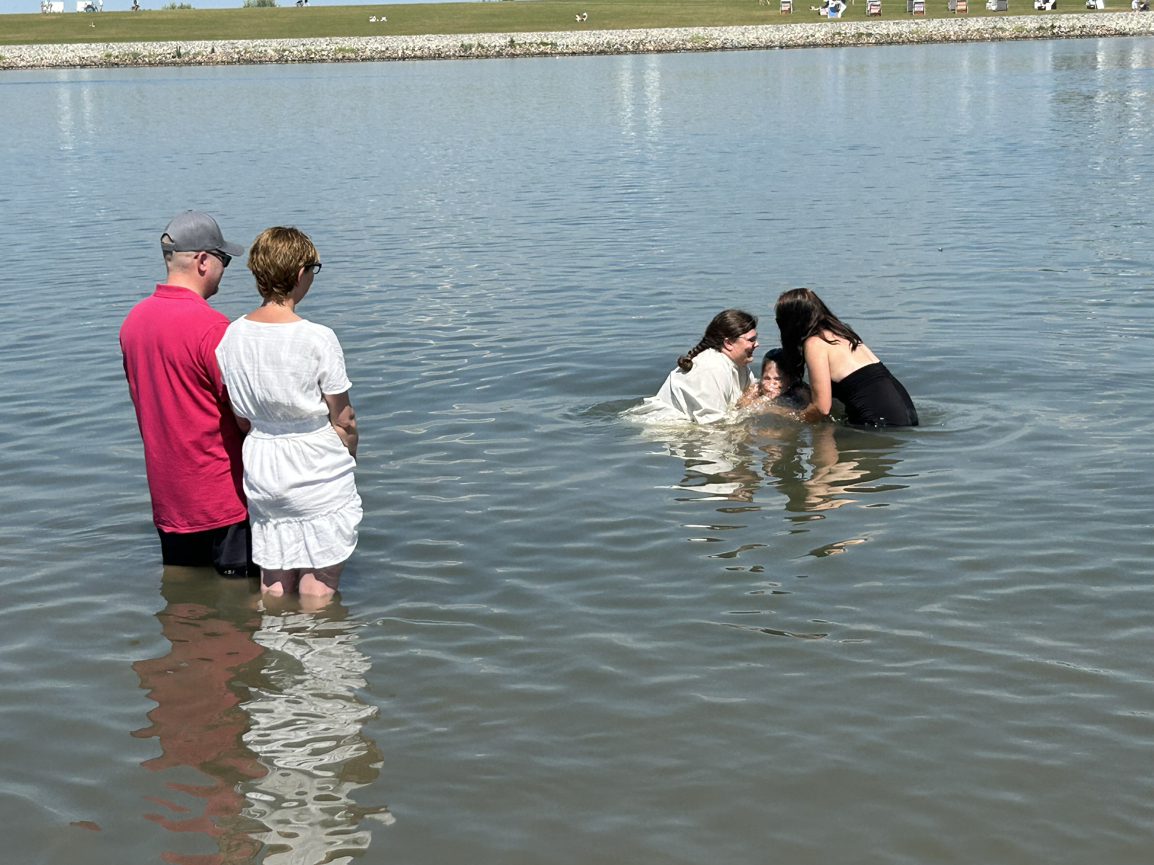 Person wird im Wasser getauft.